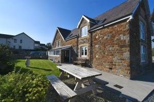 a wooden picnic table in front of a brick building at The Old Board School Guest House in St Clears