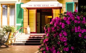une maison avec des fleurs violettes devant elle dans l'établissement Hotel Reale, à Montecatini Terme