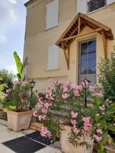 ein Haus mit rosa Blumen davor in der Unterkunft Manoir Demouret Sarlat in Sarlat-la-Canéda