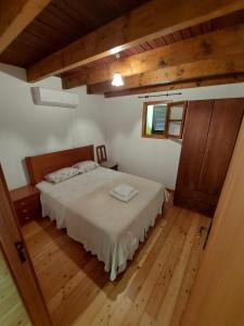 a bedroom with a bed and a wooden floor at Casa Franco in Ponta do Pargo