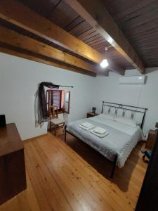 1 dormitorio con 1 cama y suelo de madera en Casa Franco, en Ponta do Pargo