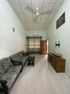 ein Wohnzimmer mit einem Sofa und einem Schreibtisch in der Unterkunft Best Homestay in Kuala Rompin