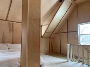 an attic room with a bed and a window at Modern Cottage Two (The Lorca, Catskills) in Shandaken