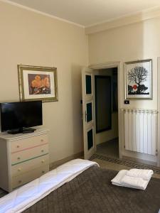 チェラーノにあるCasa nel vicolettoのベッドルーム1室(ベッド1台、ドレッサー、テレビ付)