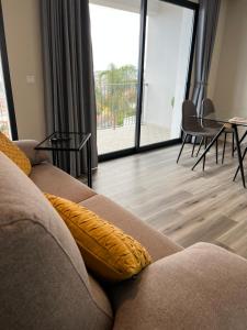 - un salon avec un canapé et une table avec des chaises dans l'établissement Dona I Apartments at Botanical Garden, à Funchal