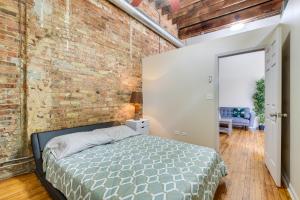 Un dormitorio con una pared de ladrillo y una cama en Central Chicago Loft Walk to Soldier Field! en Chicago