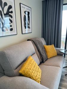a gray couch with yellow pillows in a living room at Dona I Apartments at Botanical Garden in Funchal