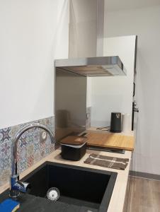 a kitchen with a sink and aaucet at Gîte Comme une parenthèse in Moissac