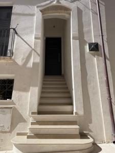 un escalier menant à une porte noire sur un bâtiment dans l'établissement Nina e il mare, à Campomarino