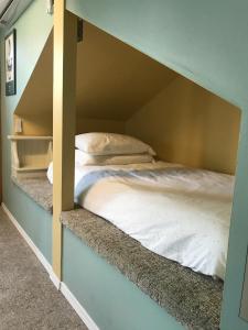 a bedroom with a bunk bed with white sheets at Lantzville Treehouse in Lantzville