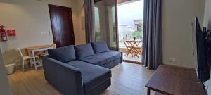 a living room with a blue couch and a table at Studio Hawana Salalah Lagoona RV10-101 in Salalah