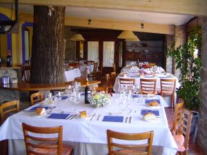 a dining room with tables with white tablecloths and chairs at Hotel Balneario Almeida Dama Verde in Almeida de Sayago