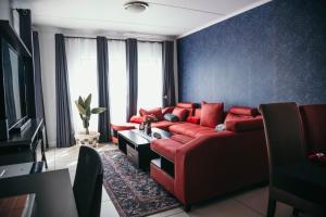 a living room with a red couch and a tv at Sizakele Stays in Johannesburg