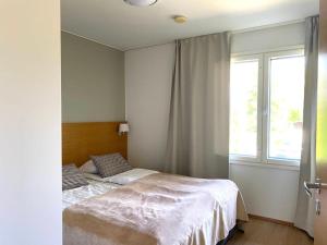 a bedroom with a bed and a window at Kylpyla SPA, lake saimaa villa in Imatra