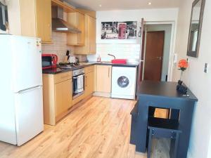 a kitchen with a white refrigerator and a washer at Cosy Studio Flat in Great Locationin London in London