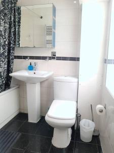 een badkamer met een wit toilet en een wastafel bij Cosy Studio Flat in Great Locationin London in Londen