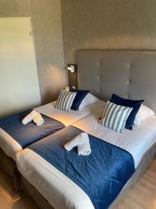two beds with towels on top of them in a bedroom at Hotel Best Western La Mare Ô Poissons in Ouistreham
