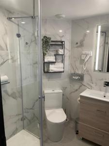 a bathroom with a shower and a toilet and a sink at Hotel Best Western La Mare Ô Poissons in Ouistreham