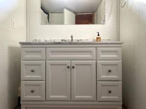 a white bathroom with a sink and a mirror at Stream House (The Lorca, Catskills) in Shandaken
