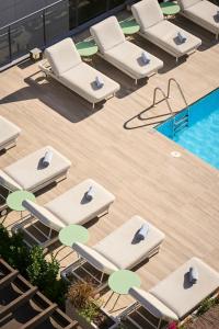 a group of lounge chairs next to a swimming pool at Catalonia Ramblas 4* Sup in Barcelona