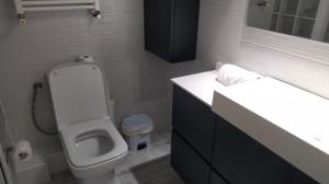 Un baño con inodoro, lavabo y espejo. en Beachfront Apartment with Sea Views & Private Parking, en Sant Pol de Mar