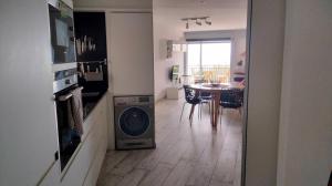 Una cocina con lavadora en el medio de una habitación. en Beachfront Apartment with Sea Views & Private Parking, en Sant Pol de Mar 6 fotos más