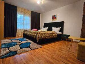 ein Schlafzimmer mit einem Bett und einem Teppich in der Unterkunft Vila Anastasia in Bistricioara
