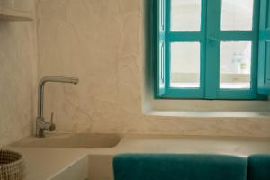 a bathroom with a bath tub and a window at Marla Luxury Residences in Megalochori
