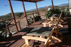 a wooden deck with a table and chairs on it at 25 Acre Hummingbird Ranch Birdwatching/360 MTN Views/Dark Starry Nights/Arizona in Pearce