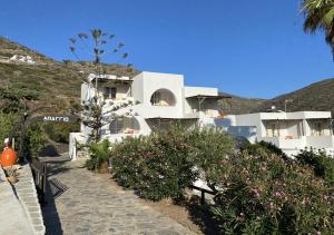 a white building with some flowers in front of it at Apaggio Apartments in Katapola