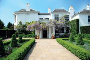 a white house with a garden with purple wisterias at The Pembroke Studio By Richmond Park in Kingston upon Thames