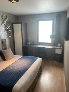 a bedroom with a bed and a desk and a window at Hotel Best Western La Mare Ô Poissons in Ouistreham