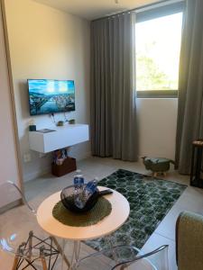 a living room with a table and a tv at Zimbali Lakes Boulevard Suites Studio Apartments in Ballito