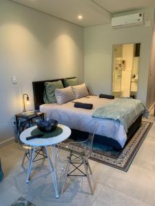 a bedroom with a bed and a table and chairs at Zimbali Lakes Boulevard Suites Studio Apartments in Ballito +53 photos