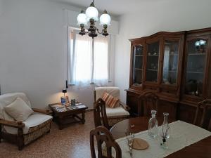 a living room with a table and chairs and a chandelier at La Vista Storica in Piombino