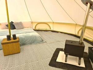 um quarto com uma cama numa tenda em Boyce Fen Farm Retreat Glamping & Fishery em Wisbech