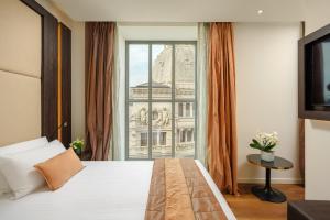 a bedroom with a bed and a large window at Hotel Dei Cavalieri Milano Duomo in Milan