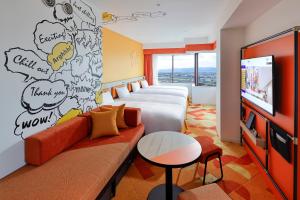 una camera d'albergo con 2 letti, un divano e una TV di Hotel Kintetsu Universal City ad Osaka