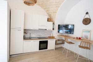 a kitchen with white cabinets and a table and chairs at Adelmarì Casa Vacanze in Manfredonia
