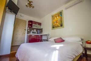 um quarto com uma cama branca e uma almofada vermelha em Sunny Split Studios em Split