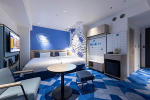 Habitación de hotel con cama, mesa y sillas en Hotel Kintetsu Universal City, en Osaka