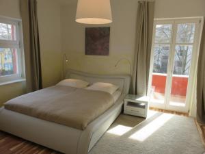 Un dormitorio con una cama y dos ventanas. en Apartement in Stadtvilla, en Berlín