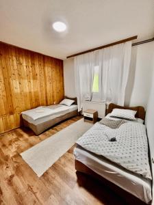 two beds in a room with wooden walls at Kuća za odmor Bilić 