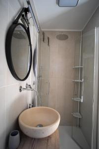 La salle de bains est pourvue d'un lavabo et d'une douche avec un miroir. dans l'établissement Adelmarì Casa Vacanze, à Manfredonia