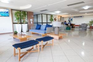 un vestíbulo con sofás azules y mesas en un edificio en Hotel Verdemar, en Salvador
