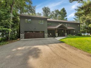a house with a driveway in front of it at Quarterdeck Resort in Nisswa