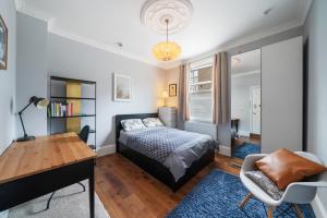 1 dormitorio con cama, escritorio y silla en Royal Greenwich Hospitality, en Londres