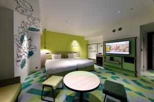 a hotel room with a bed and a flat screen tv at Hotel Kintetsu Universal City in Osaka