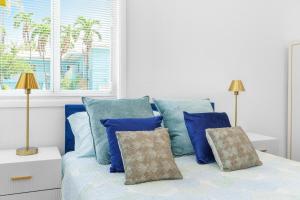 a bedroom with a bed with blue pillows and a window at 316 Seascape Unit 2 in Hollywood +21 photos