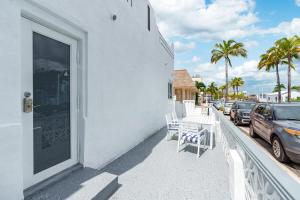 a white building with a balcony with cars parked on the street at 316 Seascape Unit 2 in Hollywood